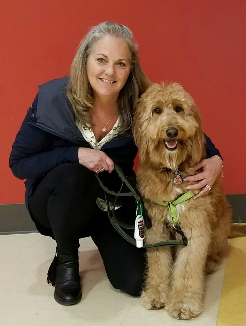 A woman and her dog are posing for the camera.