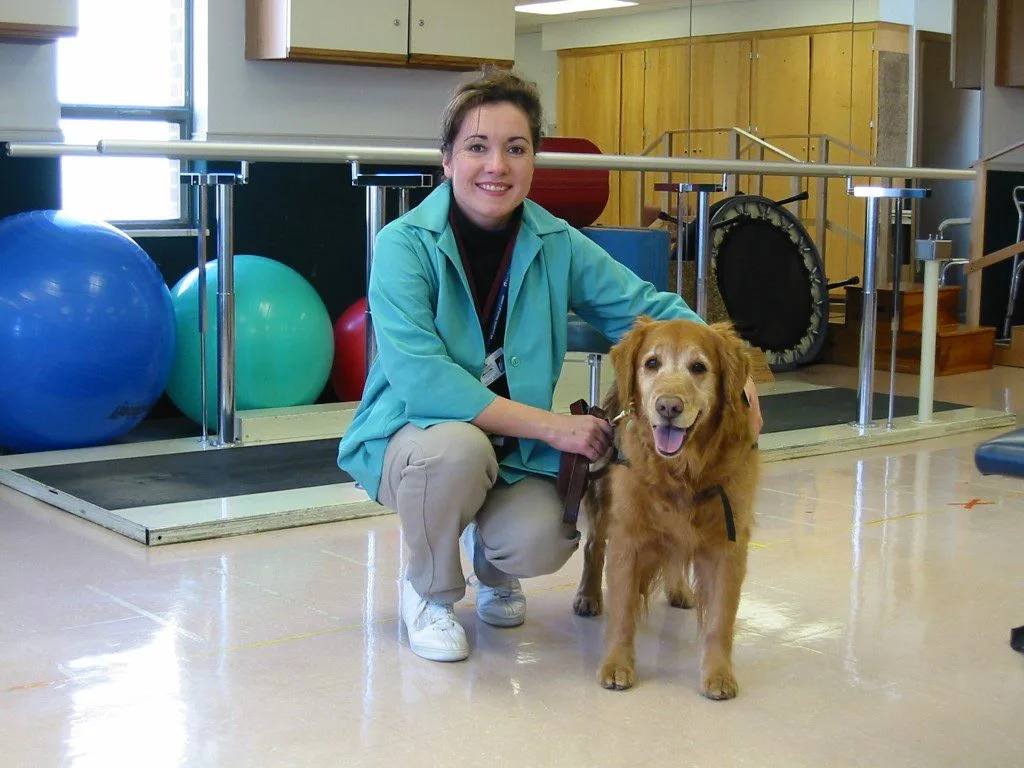 Woman in blue jacket with golden retriever.
