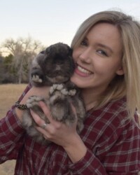 A woman holding a dog in her arms.